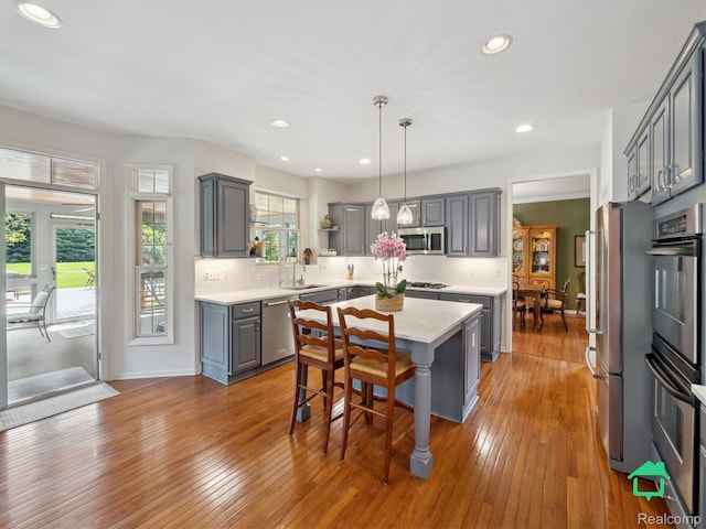 6345 Brookview Dr, Saline, MI 48176 - kitchen featuring gray cabinetry, appliances with stainless steel finishes, light countertops, hardwood / wood-style floors, and recessed lighting