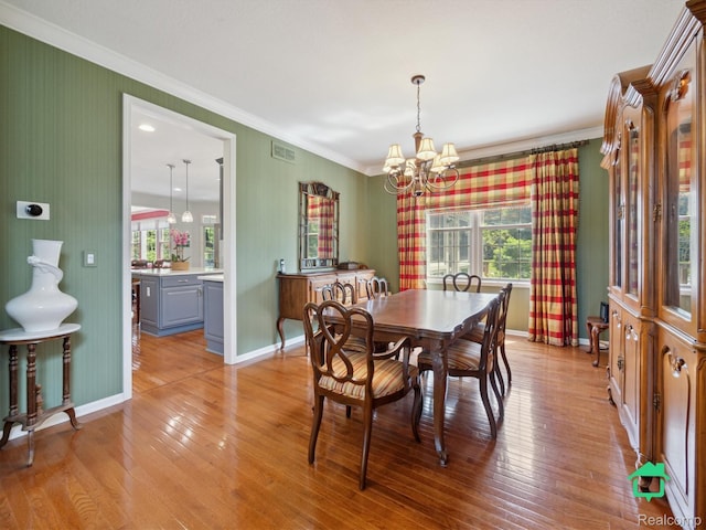 6345 Brookview Dr, Saline, MI 48176 - dining area featuring ornamental molding, a chandelier, and light wood finished floors