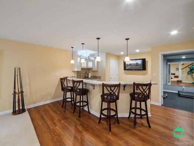 6345 Brookview Dr, Saline, MI 48176 - kitchen with dark wood-style flooring, recessed lighting, a peninsula, and a kitchen breakfast bar