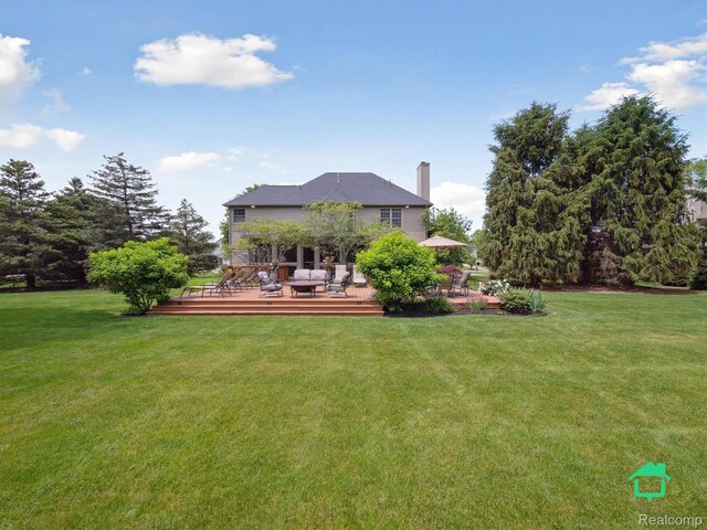 6345 Brookview Dr, Saline, MI 48176 - back of house featuring a chimney, a yard, and a wooden deck