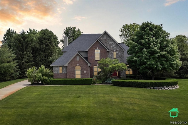 6345 Brookview Dr, Saline, MI 48176 - traditional-style house featuring a front lawn, a chimney, stone siding, and brick siding