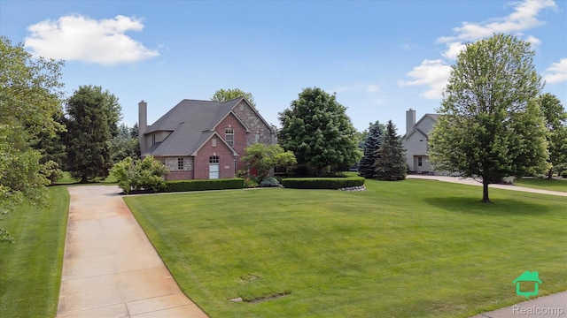 6345 Brookview Dr, Saline, MI 48176 - view of front of house featuring a front yard, stone siding, and a chimney