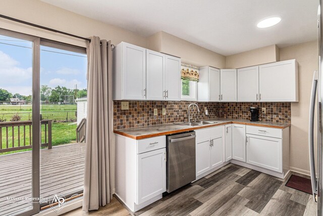 1006 Southlawn Ave, Flint, MI 48507 - kitchen featuring stainless steel dishwasher, backsplash, dark wood-style floors, and white cabinets