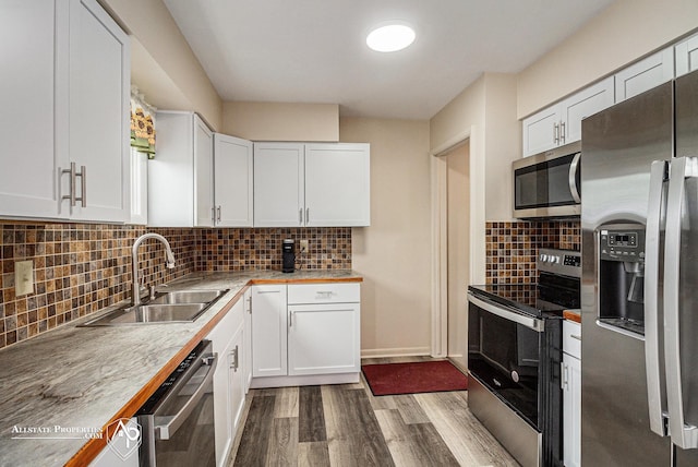 1006 Southlawn Ave, Flint, MI 48507 - kitchen with stainless steel appliances, dark wood-type flooring, white cabinets, tasteful backsplash, and light countertops