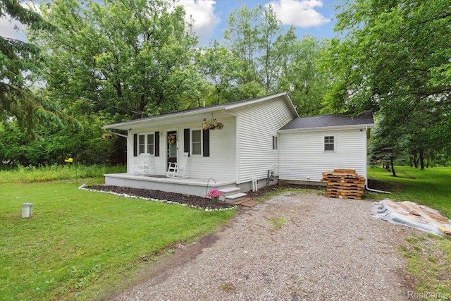759 Elm St, Allenton, MI 48002 - view of front of house featuring a porch, a front yard, and view of wooded area