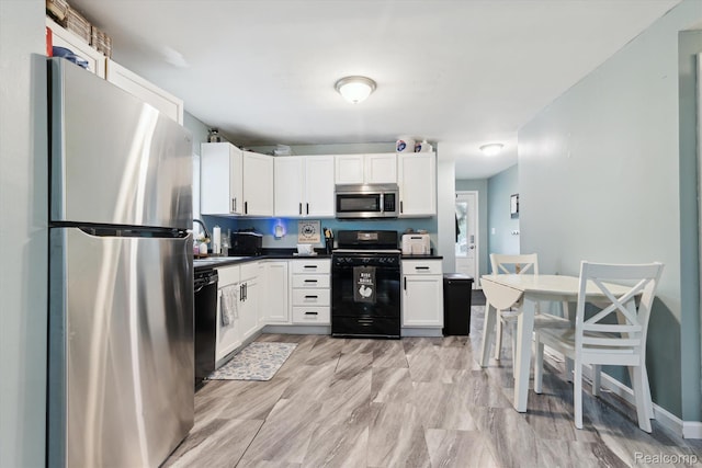 759 Elm St, Allenton, MI 48002 - kitchen with black appliances, white cabinetry, and dark countertops