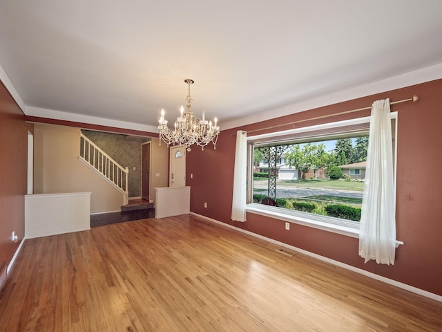 3640 Pall Dr, Warren, MI 48092 - unfurnished living room featuring wood finished floors, stairs, and a chandelier