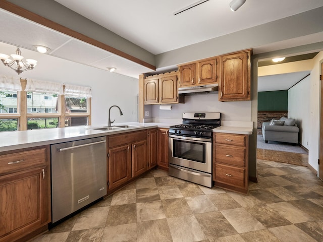 3640 Pall Dr, Warren, MI 48092 - kitchen with stainless steel appliances, light countertops, under cabinet range hood, stone finish floors, and brown cabinets
