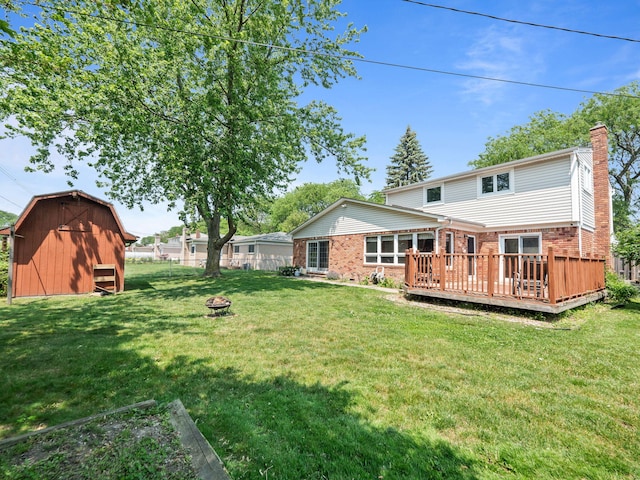 3640 Pall Dr, Warren, MI 48092 - back of house featuring brick siding, a chimney, a wooden deck, a fire pit, and an outbuilding