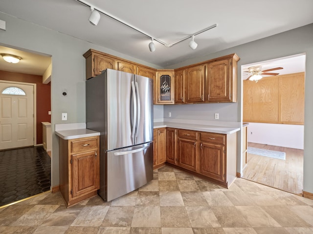 3640 Pall Dr, Warren, MI 48092 - kitchen with freestanding refrigerator, track lighting, light countertops, and brown cabinetry