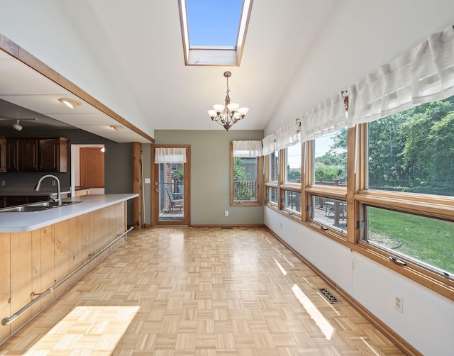 3640 Pall Dr, Warren, MI 48092 - kitchen featuring a chandelier, light countertops, a skylight, a peninsula, and high vaulted ceiling
