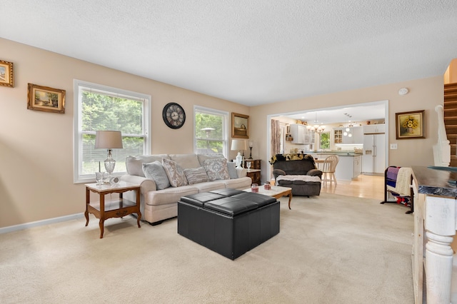 220 Deer Path Ln, Battle Creek, MI 49015 - living area featuring light colored carpet, a textured ceiling, stairway, and a chandelier
