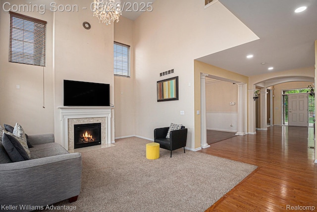 27455 Harrington Way, Novi, MI 48374 - living area with decorative columns, wood finished floors, healthy amount of natural light, a fireplace, and recessed lighting