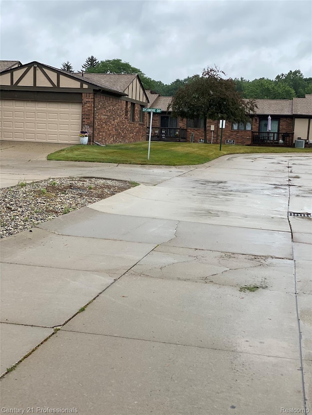 29900 N Grand Oaks Dr Unit 26, Warren, MI 48092 - view of side of property with concrete driveway, a lawn, an attached garage, and brick siding