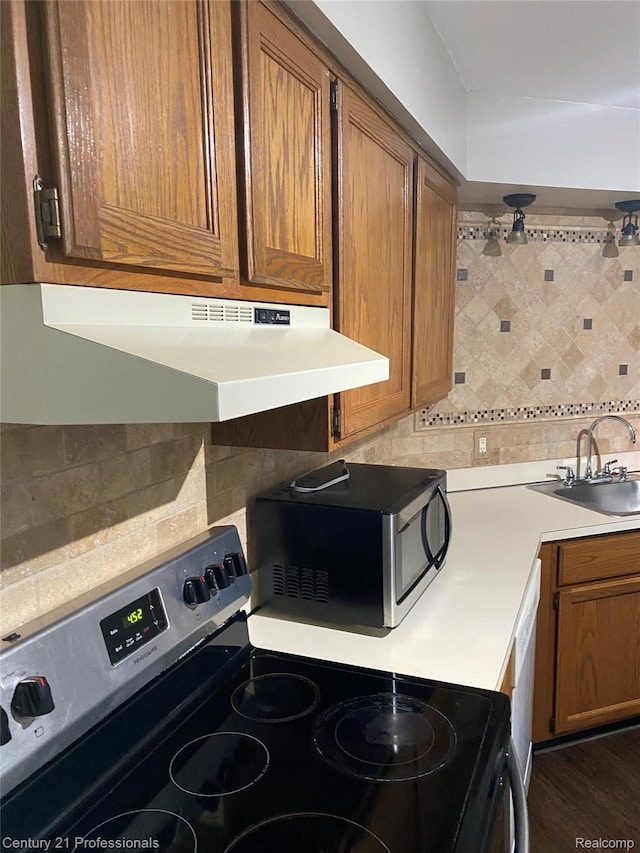 29900 N Grand Oaks Dr Unit 26, Warren, MI 48092 - kitchen featuring appliances with stainless steel finishes, extractor fan, backsplash, and brown cabinetry