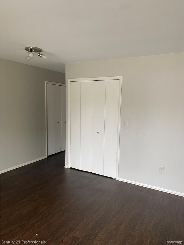 29900 N Grand Oaks Dr Unit 26, Warren, MI 48092 - unfurnished bedroom featuring dark wood-style flooring and baseboards