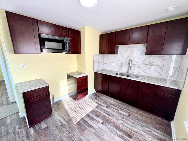 23657 Hill Ave, Warren, MI 48091 - kitchen featuring reddish brown cabinets, light wood finished floors, decorative backsplash, and light stone counters