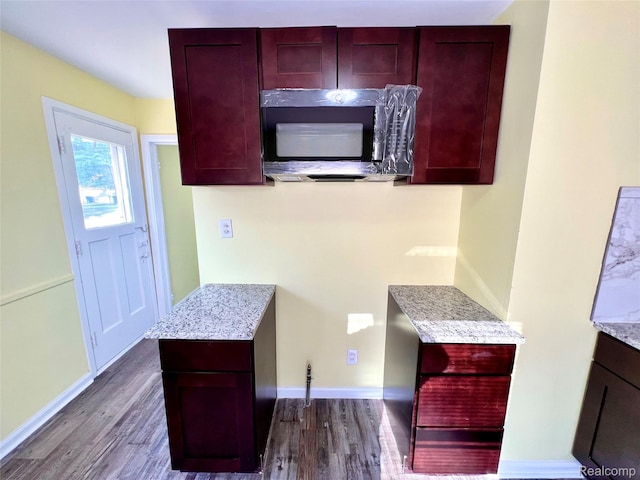 23657 Hill Ave, Warren, MI 48091 - kitchen featuring stainless steel microwave, dark wood-style floors, reddish brown cabinets, and light stone countertops