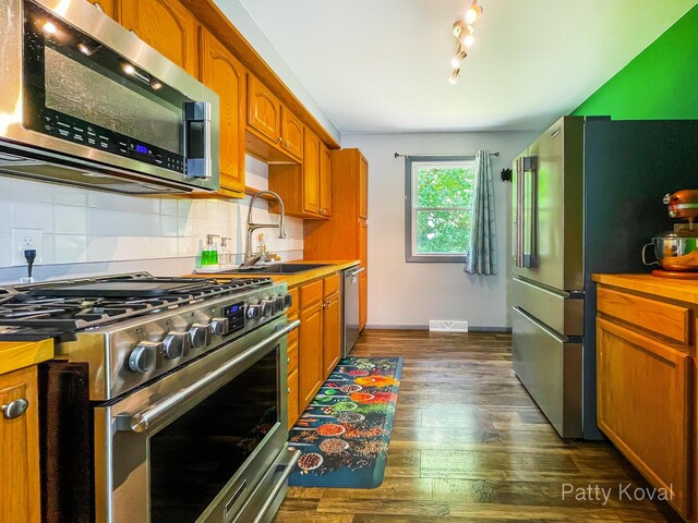 4164 Madison Ave SE, Grand Rapids, MI 49548 - kitchen featuring appliances with stainless steel finishes, dark wood-style floors, backsplash, brown cabinets, and light countertops