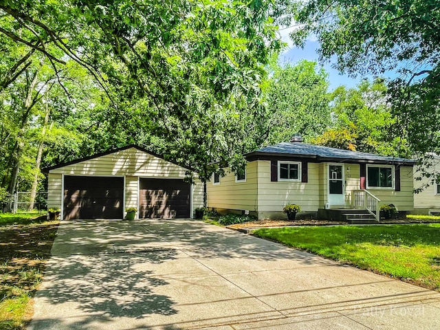 4164 Madison Ave SE, Grand Rapids, MI 49548 - view of front of house featuring a garage, an outbuilding, a front yard, and a chimney