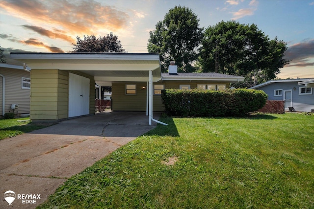3606 Pingree Ave, Flint, MI 48503 - view of front of house featuring concrete driveway, a yard, an attached carport, and a chimney