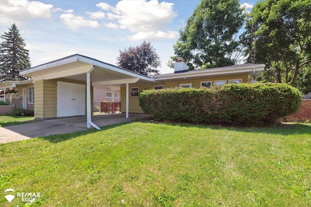 3606 Pingree Ave, Flint, MI 48503 - ranch-style house featuring an attached carport, a front yard, concrete driveway, and a chimney