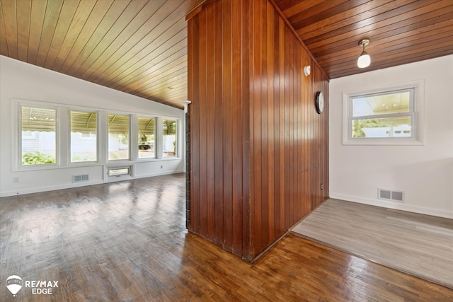 3606 Pingree Ave, Flint, MI 48503 - spare room with vaulted ceiling, wood ceiling, healthy amount of natural light, dark wood finished floors, and wooden walls