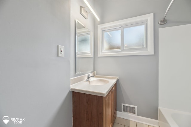 3606 Pingree Ave, Flint, MI 48503 - bathroom with vanity, a tub, and tile patterned floors