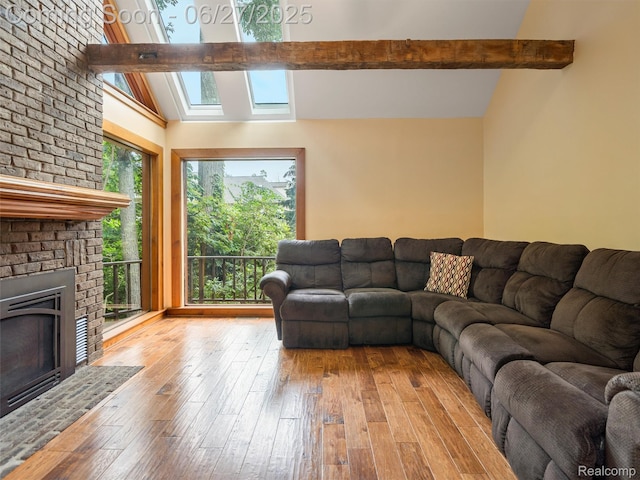9767 Whisperwood Ln, Brighton, MI 48116 - living room featuring hardwood / wood-style floors, a fireplace, and a skylight