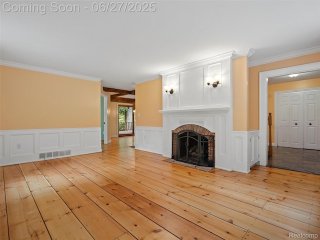 9767 Whisperwood Ln, Brighton, MI 48116 - unfurnished living room with ornamental molding, light wood finished floors, a fireplace, a decorative wall, and a wainscoted wall