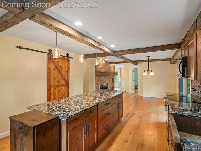 9767 Whisperwood Ln, Brighton, MI 48116 - kitchen featuring stainless steel range with electric cooktop, black microwave, light wood-style floors, beam ceiling, and a kitchen island