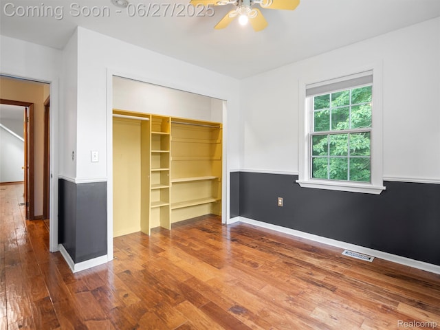 9767 Whisperwood Ln, Brighton, MI 48116 - unfurnished bedroom with a closet, hardwood / wood-style floors, and a ceiling fan