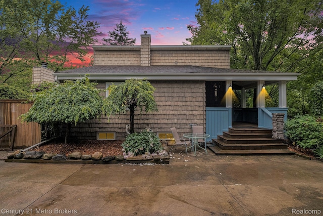 6428 W Court St, Flint, MI 48532 - view of front of home with a chimney, roof with shingles, and a patio area