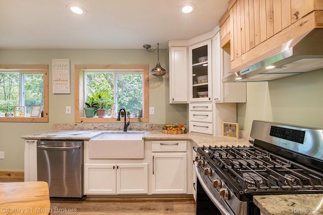 6428 W Court St, Flint, MI 48532 - kitchen featuring stainless steel appliances, under cabinet range hood, light stone counters, white cabinets, and plenty of natural light