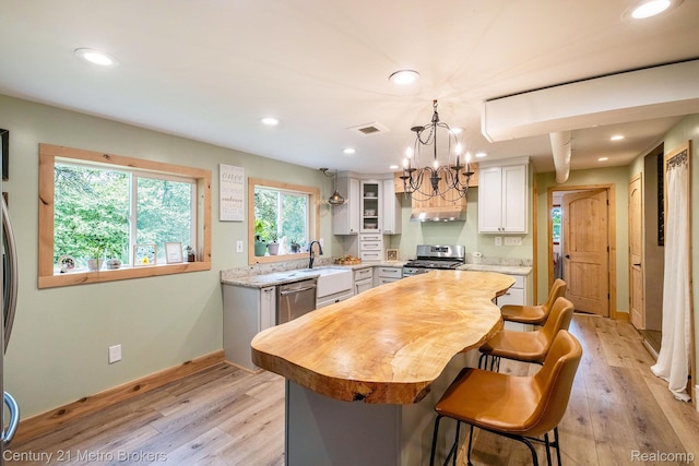 6428 W Court St, Flint, MI 48532 - kitchen featuring stainless steel appliances, recessed lighting, a center island, light wood-type flooring, and a chandelier