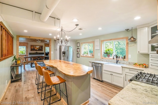 6428 W Court St, Flint, MI 48532 - kitchen featuring stainless steel appliances, recessed lighting, white cabinetry, light wood finished floors, and a center island