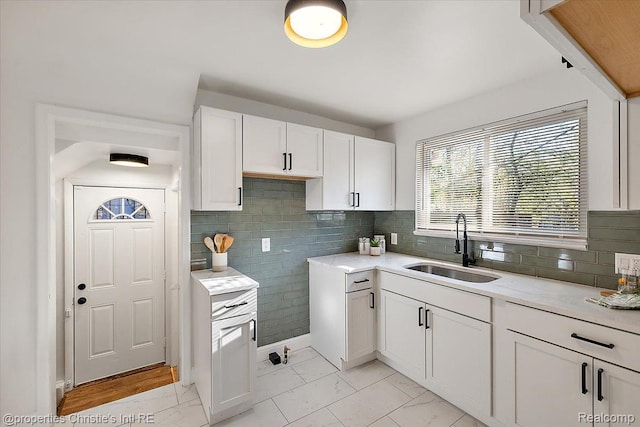 16573 Griggs St, Detroit, MI 48221 - kitchen with white cabinets, tasteful backsplash, and light marble finish flooring