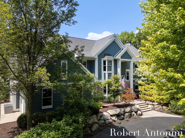1977 Emerald Glen Ct NE, Ada, MI 49301 - view of front of home with a shingled roof, a chimney, and a garage