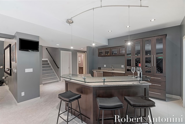 1977 Emerald Glen Ct NE, Ada, MI 49301 - kitchen featuring dishwasher, a center island, glass insert cabinets, a kitchen bar, and dark brown cabinetry