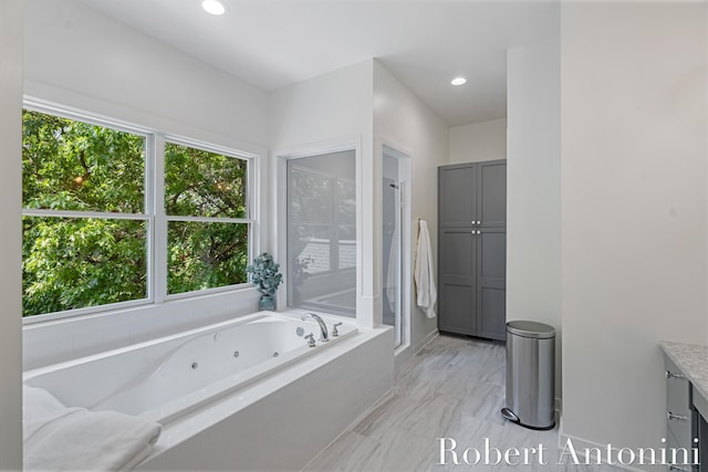 1977 Emerald Glen Ct NE, Ada, MI 49301 - bathroom with vanity, healthy amount of natural light, a tub with jets, recessed lighting, and marble finish flooring