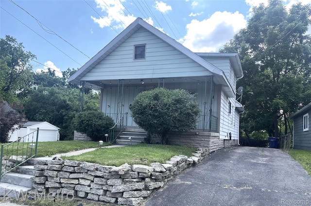 103 N Roselawn St, Pontiac, MI 48342 - view of front of house featuring a front yard, an outbuilding, and board and batten siding