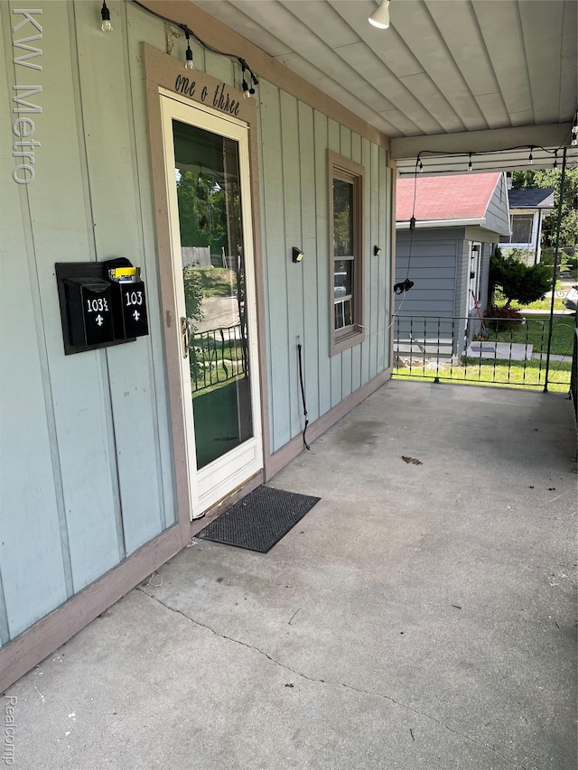 103 N Roselawn St, Pontiac, MI 48342 - doorway to property featuring board and batten siding and an attached carport