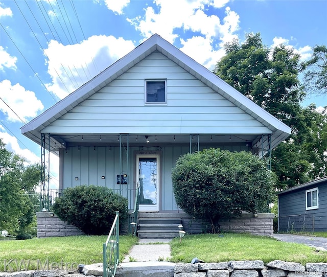 103 N Roselawn St, Pontiac, MI 48342 - bungalow-style house with a porch, a front lawn, and board and batten siding