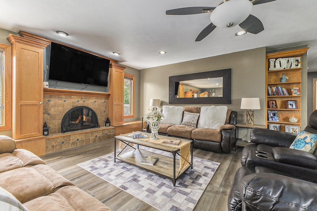 9749 48th Ave, Allendale, MI 49401 - living room featuring a ceiling fan, wood finished floors, a stone fireplace, built in features, and recessed lighting