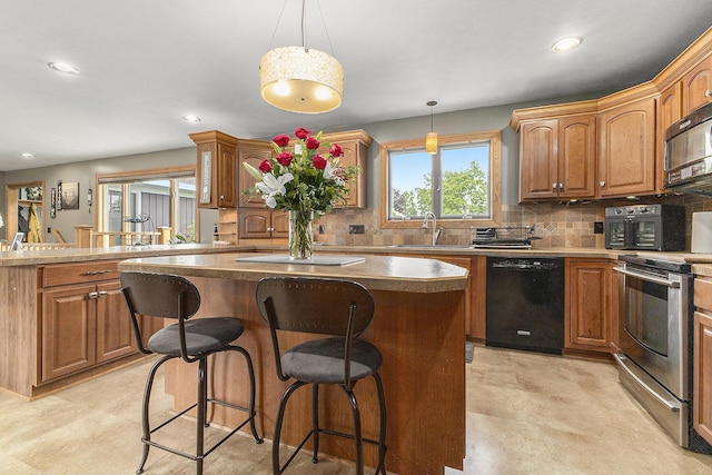 9749 48th Ave, Allendale, MI 49401 - kitchen featuring black appliances, a kitchen island, a kitchen breakfast bar, tasteful backsplash, and recessed lighting