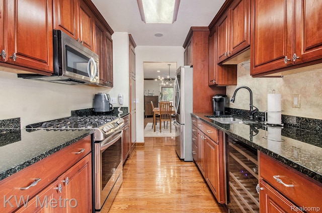 6271 Potomac Cir W, Bloomfield, MI 48322 - kitchen featuring appliances with stainless steel finishes, wine cooler, light wood-style flooring, dark stone counters, and a chandelier