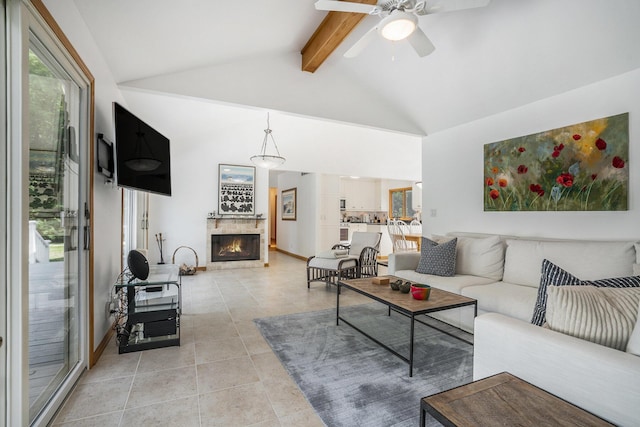 6368 E Lake Ln, Sawyer, MI 49125 - living room with beam ceiling, ceiling fan, light tile patterned floors, a warm lit fireplace, and high vaulted ceiling