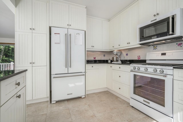 6368 E Lake Ln, Sawyer, MI 49125 - kitchen with white appliances, dark countertops, and decorative backsplash