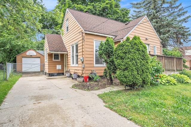 134 Honeoye St SW, Grand Rapids, MI 49548 - view of front facade with roof with shingles, a detached garage, an outbuilding, driveway, and a gate