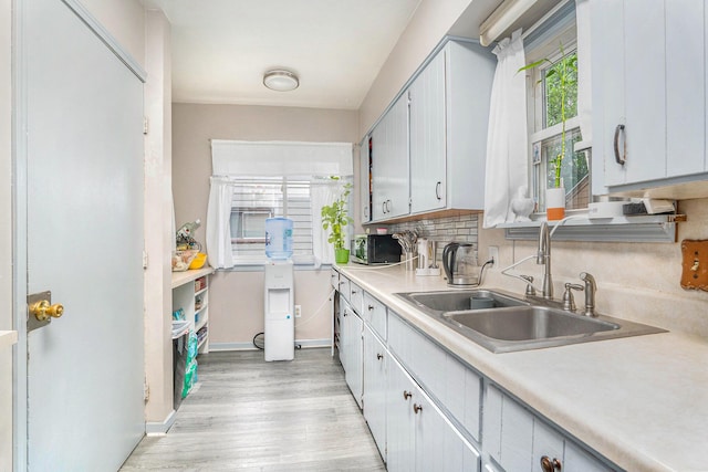 134 Honeoye St SW, Grand Rapids, MI 49548 - kitchen featuring light countertops, light wood-style flooring, and backsplash